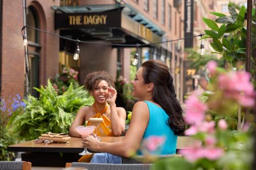 ボストンにあるThe Dagny Bostonの二人の女性がレストランの外のテーブルに座っている
