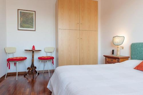 een slaapkamer met een bed en 2 stoelen en een tafel bij Appartamento con garage vicino al centro in Verona