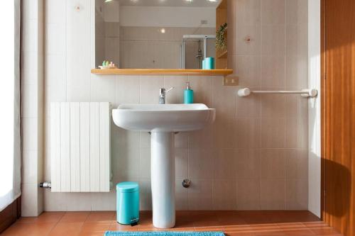 een badkamer met een witte wastafel en een spiegel bij Appartamento con garage vicino al centro in Verona