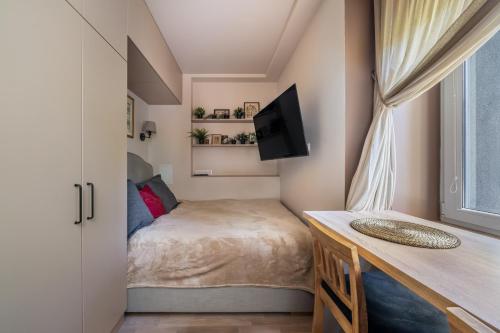 Un dormitorio pequeño con una cama y una ventana. en Dzintaru 48 studio, en Jūrmala