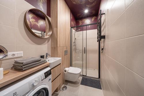 Un baño con un inodoro, un lavabo y un espejo. en Dzintaru 48 studio, en Jūrmala