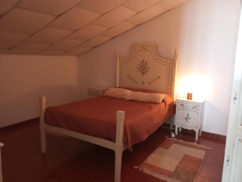 a bedroom with a bed with a orange bedspread at Sótão dos Avós do Monte Beatriz in Reguengos de Monsaraz