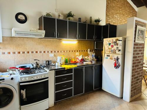 a kitchen with a stove and a white refrigerator at Villa emma in Villa General Belgrano