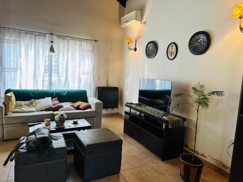 sala de estar con sofá y mesa en Villa emma en Villa General Belgrano