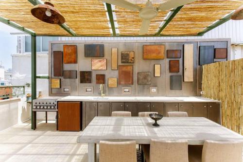 una cocina con mesa y sillas y una pared con obras de arte en Shuk Museum, en Tel Aviv
