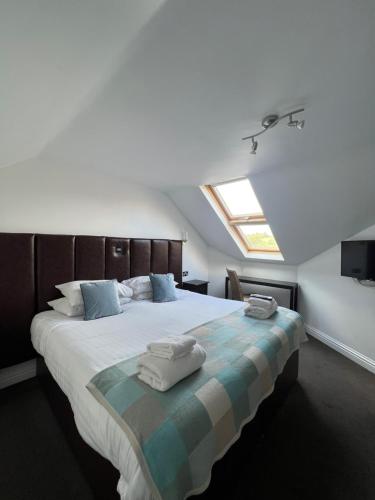 - une chambre avec un grand lit et des serviettes dans l'établissement The Inn on the Loch, à Castle Douglas