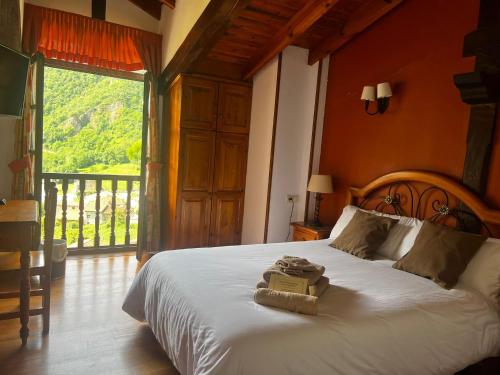a bedroom with a bed and a large window at Hotel Rural El Sestil in Dobres