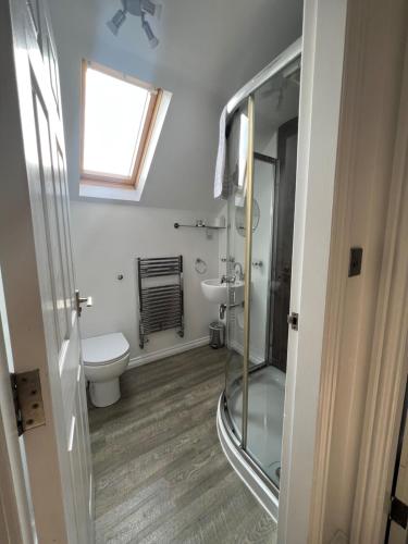uma casa de banho com um chuveiro, um WC e um lavatório. em The Inn on the Loch em Castle Douglas