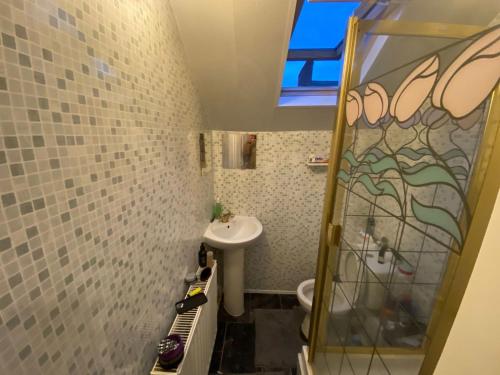 een kleine badkamer met een wastafel en een douche bij Lovely room 5 minute walk from city centre in Newcastle upon Tyne