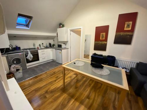a living room with a table and a kitchen at Lovely room 5 minute walk from city centre in Newcastle upon Tyne