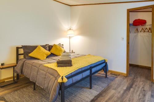 a bedroom with a bed with yellow and blue pillows at Charming Watkins Glen Home with Deck and Yard! in Watkins Glen