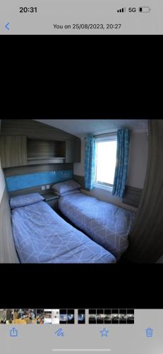 two beds in a room with a window at 87 kyntyre view Craig tara in Ayr