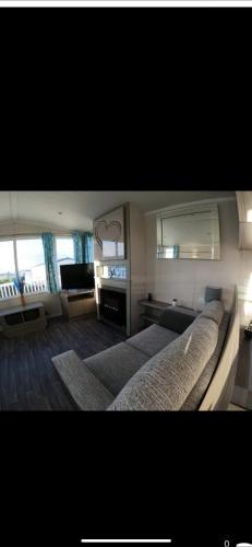 a bedroom with a large bed and a living room at 87 kyntyre view Craig tara in Ayr