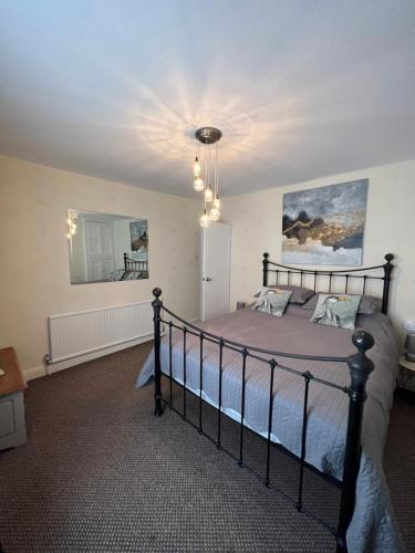 a bedroom with a bed and a chandelier at Park cottage High Crompton in Shaw