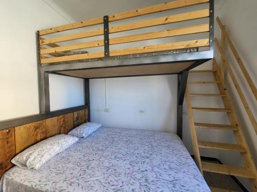 1 dormitorio con litera y escalera en Casa Serrans en Cala Mesquida