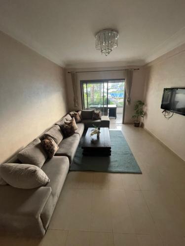 sala de estar con sofá y TV en Blanca Beach, en Sidi Rahal