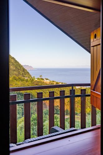 a room with a balcony with a view of the ocean at Villa Fontes 7 in Ponta Delgada
