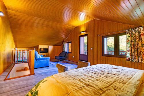 a bedroom with a large bed and a living room at Villa Fontes 7 in Ponta Delgada