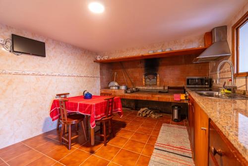 a kitchen with a table with a red table cloth at Villa Fontes 7 in Ponta Delgada