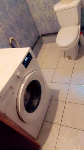 a washing machine in a bathroom with a toilet at Ramakyri rom in Douala