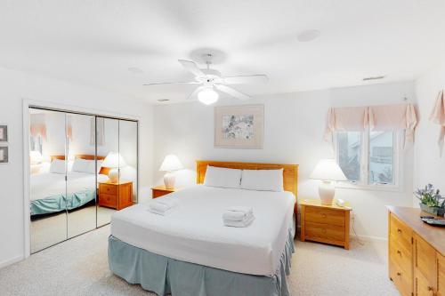 1 dormitorio con 1 cama blanca grande y espejo en Rudi's Retreat 664, en Corolla
