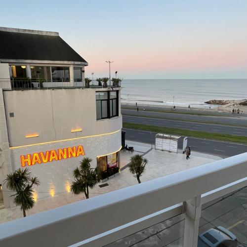 a building with a hawaiian sign on it next to the beach at Excelente! 4 personas frente al mar con cochera in Mar del Plata