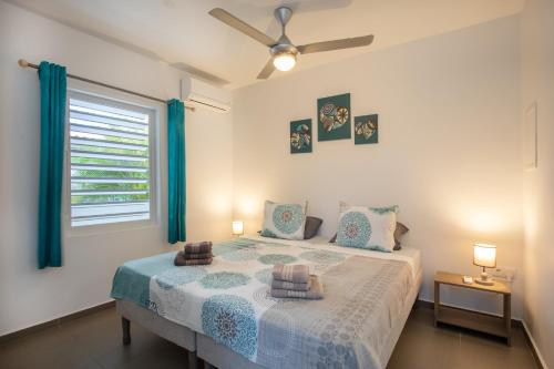 a bedroom with a bed with green curtains and a window at Paradise Apartments - Curacao in Fontein