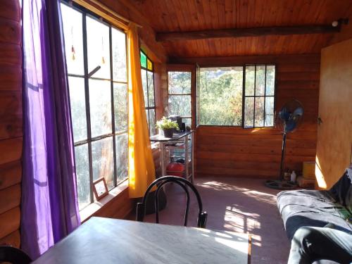 Cette chambre dispose de fenêtres et d'une table. dans l'établissement Hostel Alfa, à San Marcos Sierras