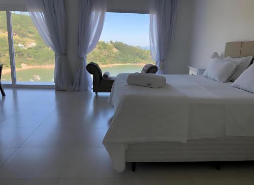 a bedroom with a large bed and a large window at Mar de Bougainville in Governador Celso Ramos