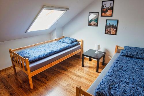 een slaapkamer met 2 bedden en een dakraam bij Noclegi Wrzosowa Siedlce in Grabianów