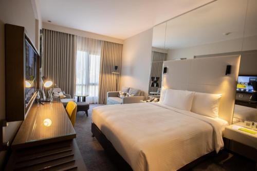 ein Hotelzimmer mit einem Bett und einem Wohnzimmer in der Unterkunft Almorqqabat Rooms in Dubai