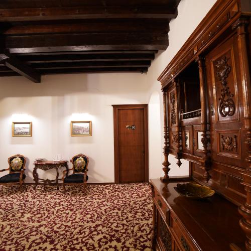 a living room with a large wooden cabinet and a table at Panderma Port Hotel in Bandırma