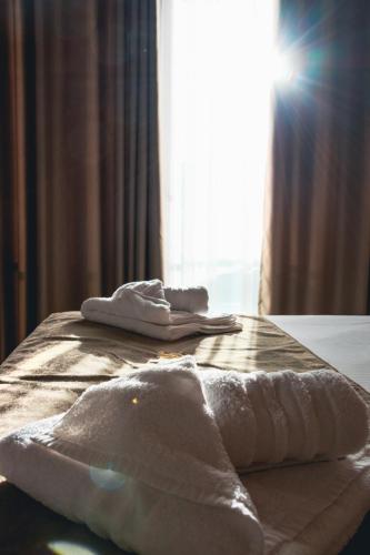 a bed with towels sitting on top of it at Kronos Hotel in Durrës