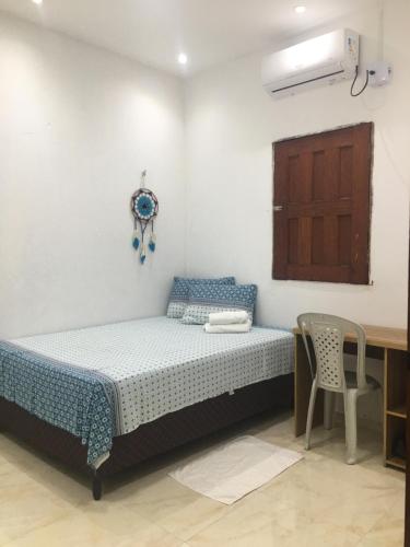 a bedroom with a bed and a table and a chair at Rosana House Bem estar em Barreirinhas Ideal para 5 pessoas in Barreirinhas