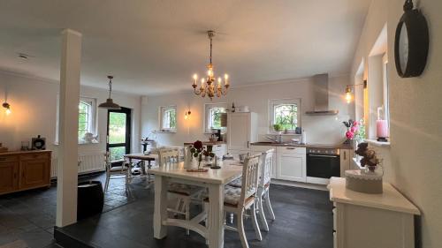 a kitchen with a table and chairs in a room at Ferienhaus Villa Vogelsang (Schlei / Ostsee) in Stoltebüll