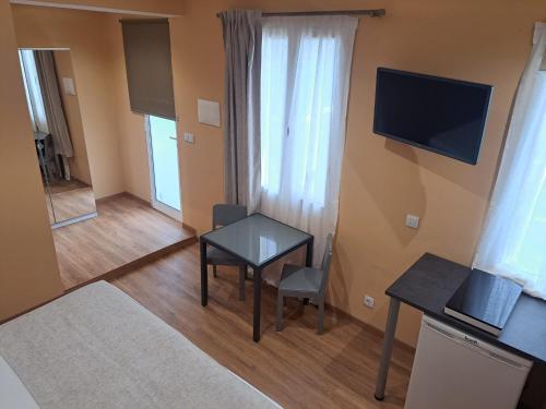 a small living room with a table and a television at Calheta Countryside in Calheta