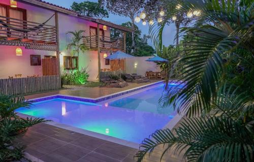 a swimming pool in front of a house at Pousada Vila Mangaba in Arraial d'Ajuda