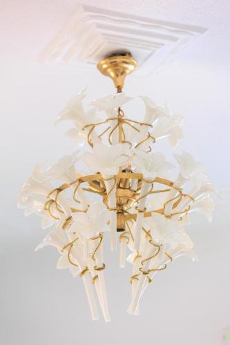 a chandelier with white flowers on a ceiling at Aerno Home & Azul Ηοme - Ahilli Slow Living in Kamari