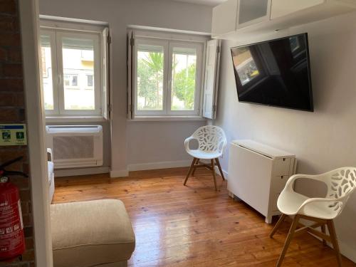 a living room with two chairs and a tv at T2 Alvalade em Lisboa para 3 Pessoas in Lisbon