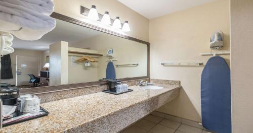 a bathroom with a sink and a large mirror at Best Western Roseville Inn in Roseville