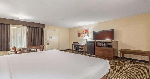 a hotel room with a bed and a flat screen tv at Best Western Roseville Inn in Roseville