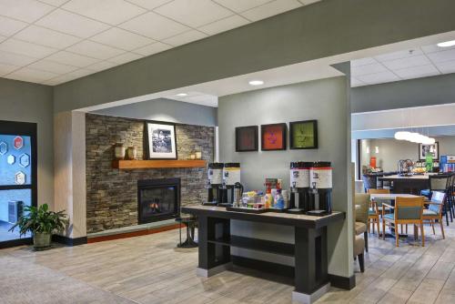 a waiting room with a fireplace and a bar at Hampton Inn Lewisburg in Lewisburg