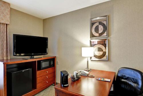 a hotel room with a television and a desk with a telephone at Hampton Inn Lewisburg in Lewisburg