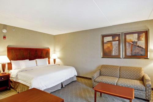 a hotel room with a bed and a chair at Hampton Inn Lewisburg in Lewisburg