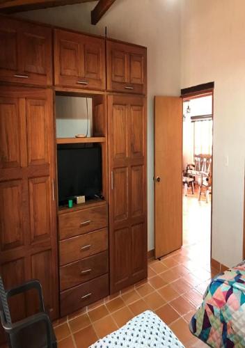 a bedroom with a entertainment center with a flat screen tv at Hospedaje Villa Sofía Barichara ST Santander in Barichara