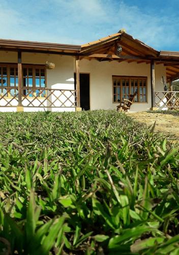 a house with a green hedge in front of it at Hospedaje Villa Sofía Barichara ST Santander in Barichara