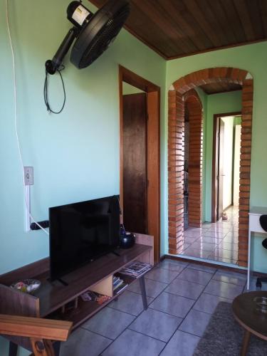 a living room with a flat screen tv at Hospedaria das Azaleias in Novo Hamburgo