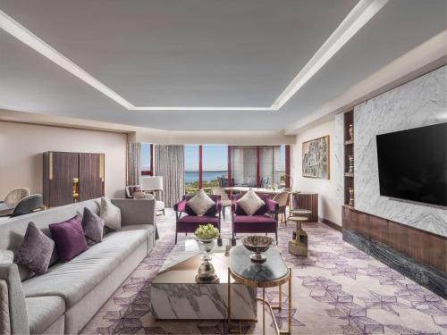 a living room with a couch and a tv at Jeddah Hilton in Jeddah