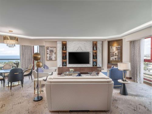 a living room with a large couch and a tv at Jeddah Hilton in Jeddah