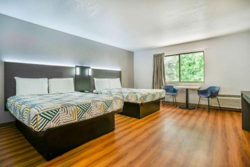 格雷善的住宿－俄勒岡州波特蘭格雷舍姆6號汽車旅館，酒店客房设有两张床、一张书桌和一个窗户。